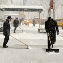 Various men shoveling snow on Fifth Ave between 76th and 75th streets, NYC