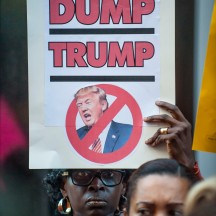 Protestors holding signs at protest in front of Trump Tower, objecting to Donald Trump's treatment of women.