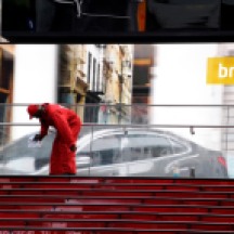 Worker cleaning glass, appearing to be washing car on billboard. Times Square, NYC.