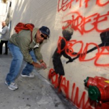 Richard Santiago AKA 'Apollo', an old-school NYC graffiti artist, removing plexiglass cover on Banksy painting, West 79th Street @ Broadway, NYC.